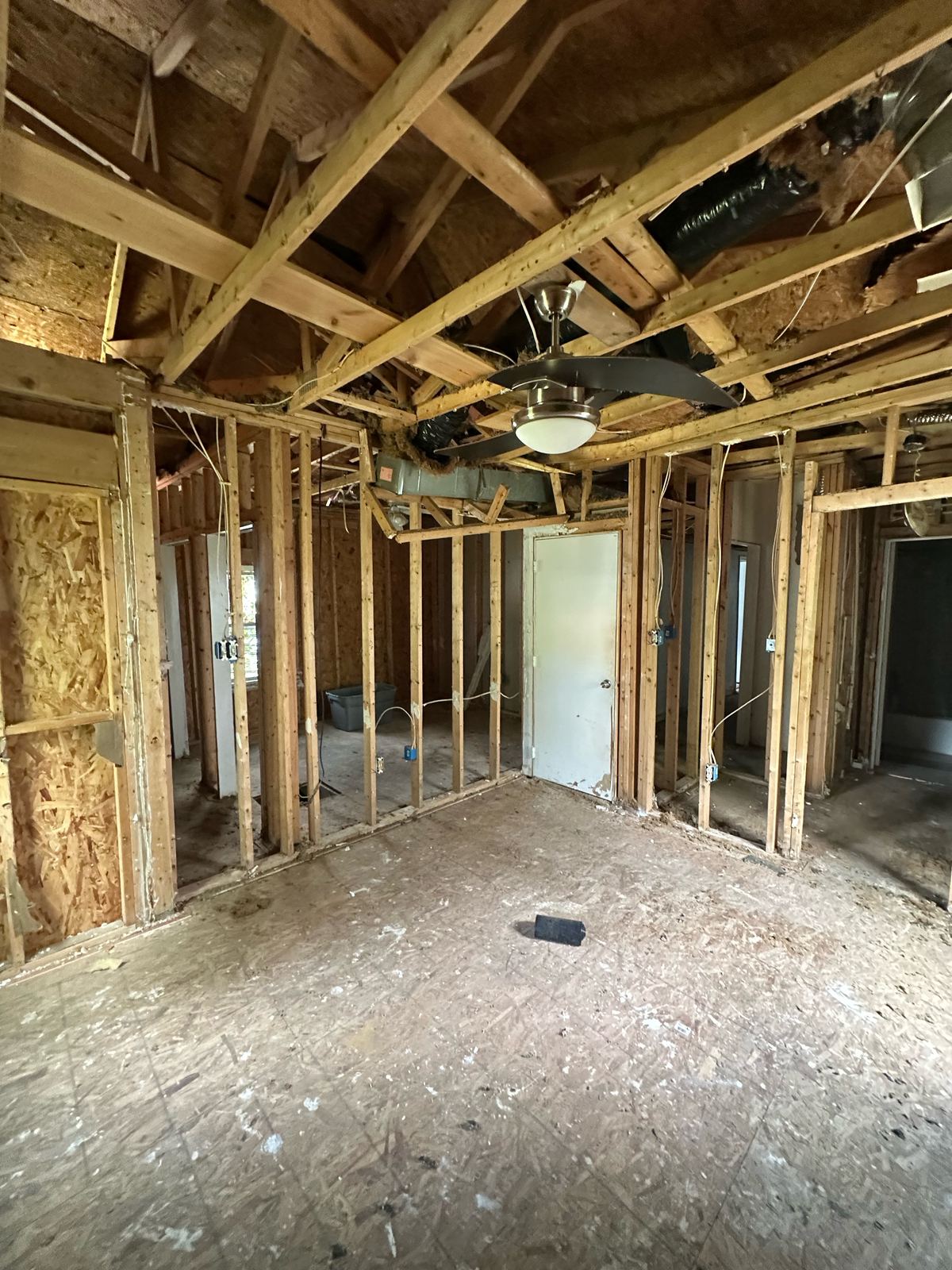 Gutted room down to the studs with exposed ceiling joists and new framing